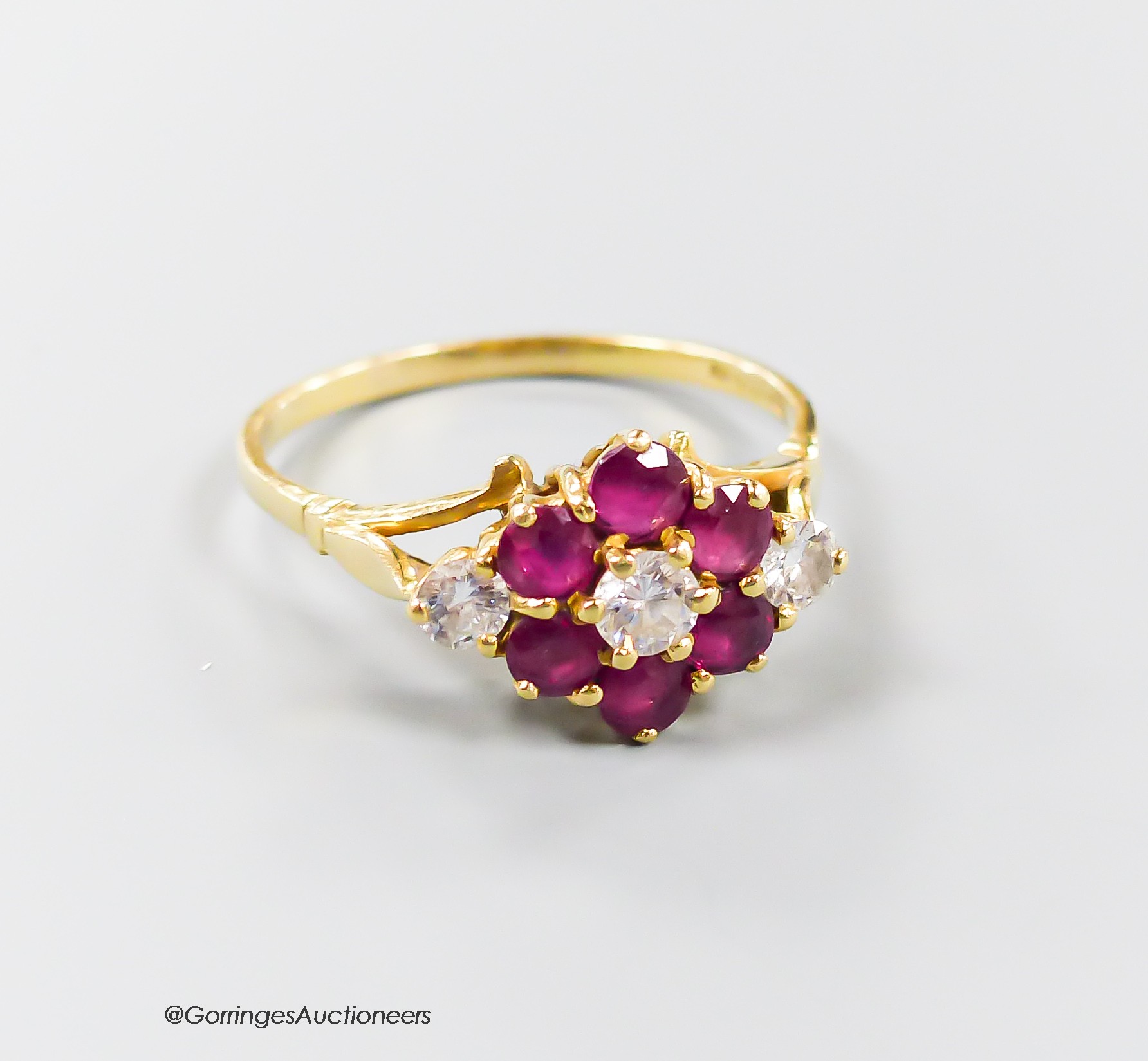 A modern 18ct gold, ruby and diamond set cluster ring, size T, gross 3.8 grams.